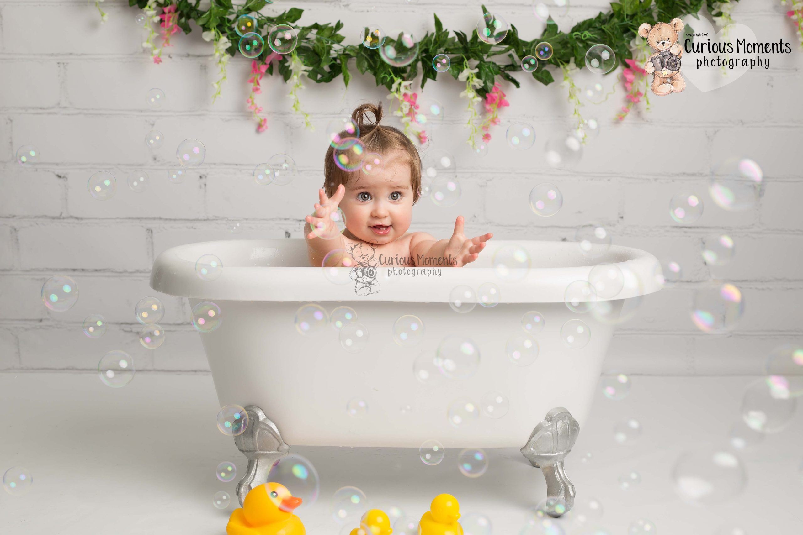 Baby girl in bath Tub playing with bubbles