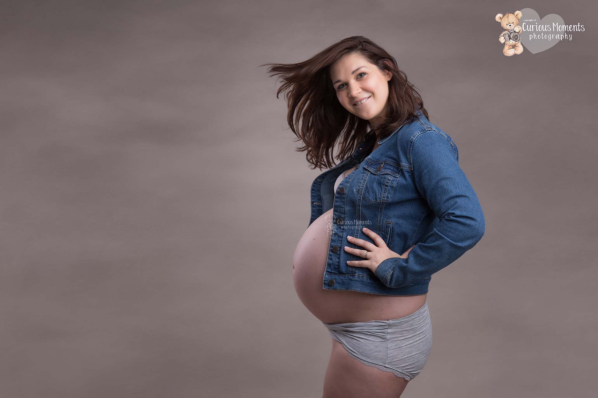 pregnant mum to be with bump wearing denim jacket in studio with Maternity Photographer Carmarthen