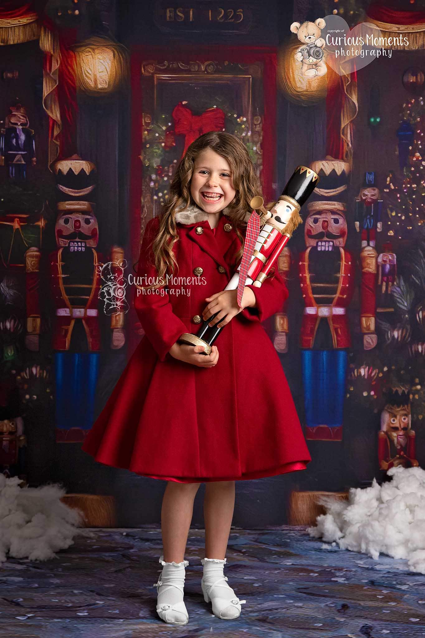 Christmas phot shoot girl holding nutcracker outside toy shop