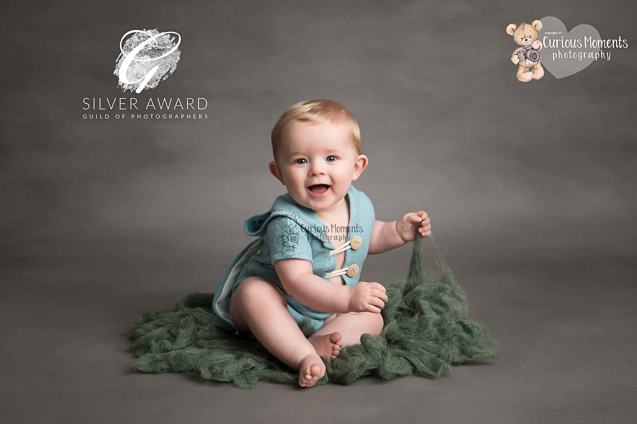 Award winning image taken by best baby photographer of baby boy sat on green fluffy mat